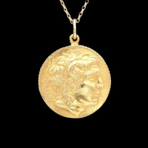 a gold coin necklace with a woman's face on it