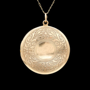 an antique gold locke necklace with the image of a woman