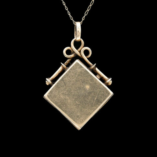 an old key and square pendant on a chain