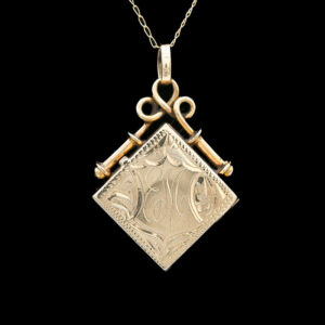 a gold pendant with two keys hanging from it