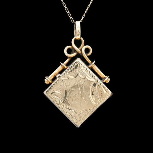 a gold pendant with two keys hanging from it