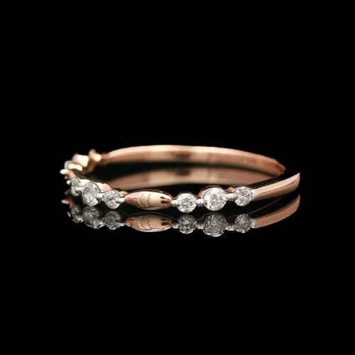 a rose gold and diamond ring on a black background