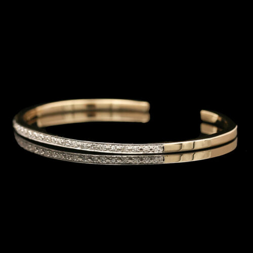 a close up of a gold and diamond bracelet