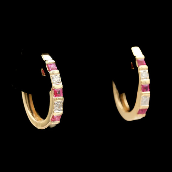 two gold hoop earrings with pink and white stones
