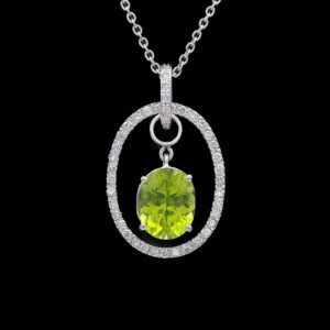 an oval pendant with a green stone surrounded by diamonds