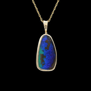 a pendant with a blue and green design on it