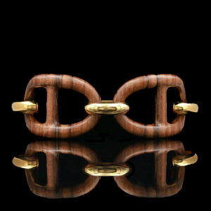 a wooden cuff with two gold rings on it