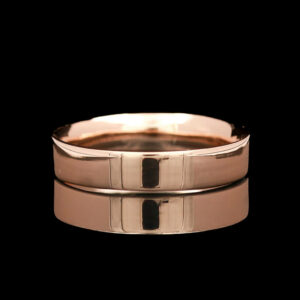 two wedding bands in rose gold on a black background