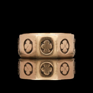 a gold ring with four clovers on it