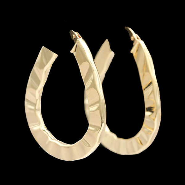 a pair of gold hoop earrings on a black background