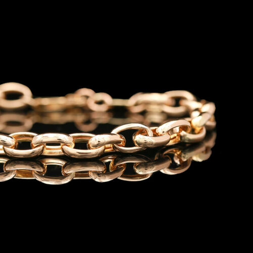 a close up of a gold bracelet on a black background