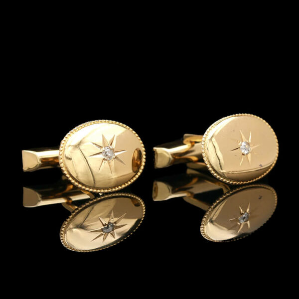 a pair of gold cufflinks with diamonds