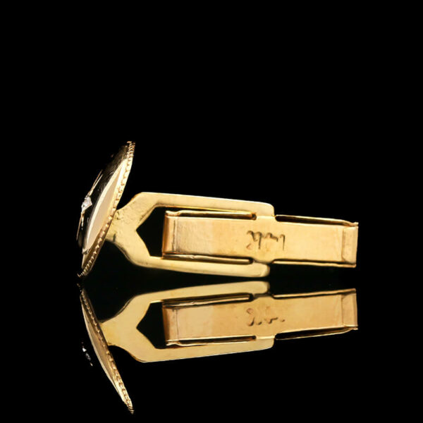 a pair of gold cufflinkes sitting on top of a black surface