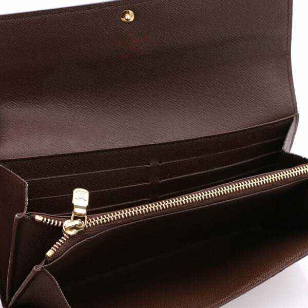 a brown purse with a zipper open on a white surface
