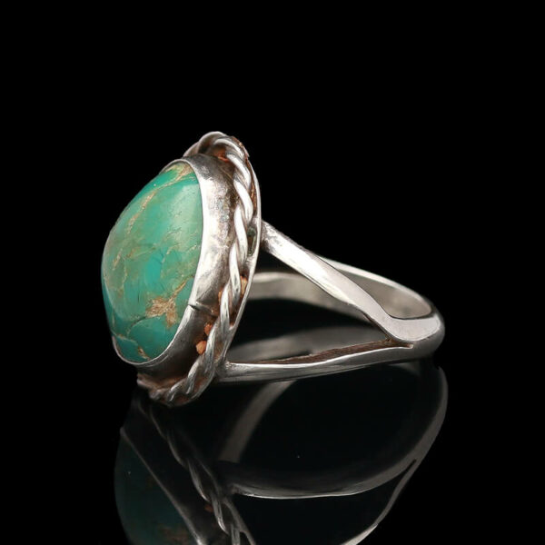 a silver ring with a turquoise stone in it