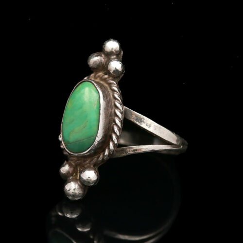 a silver ring with a green stone on it