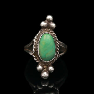 a silver ring with a green stone in the center