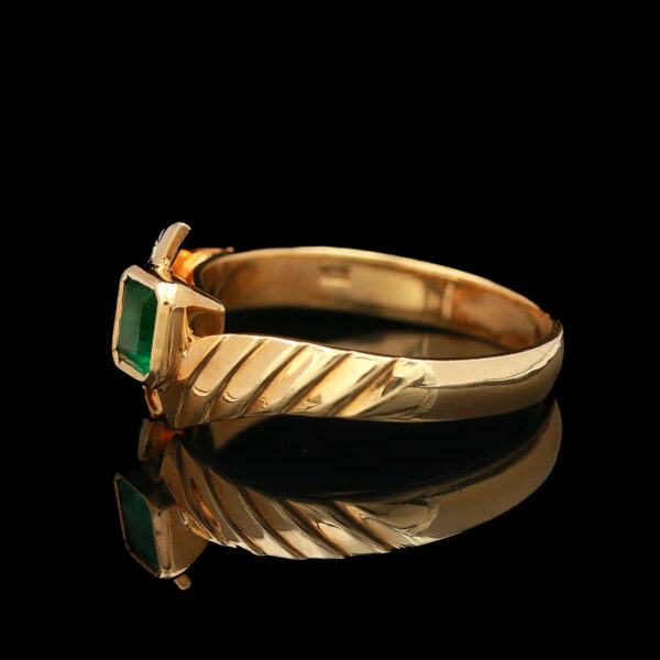 a gold ring with an emerald stone in the center