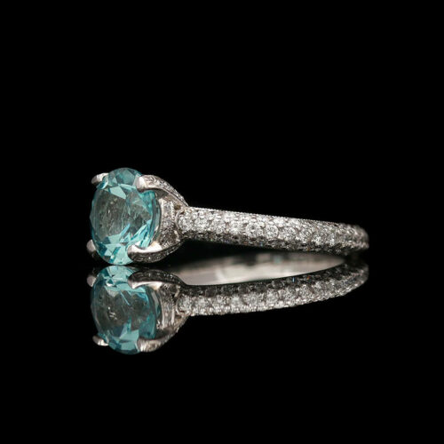 an aqua and diamond ring on a black background