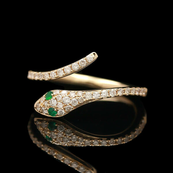 a diamond and emerald ring on a black background