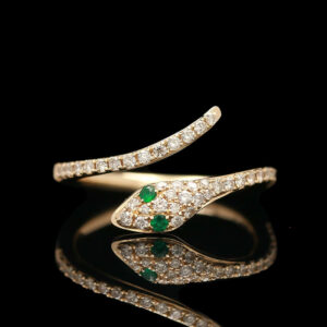 a diamond and emerald ring on a black background