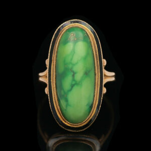 a gold and green stone ring on a black background