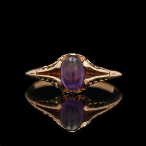 a ring with an oval shaped purple stone
