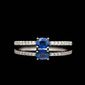 a blue sapphire and diamond ring on a black background