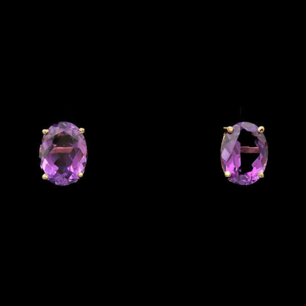 two pairs of earrings with purple stones on them