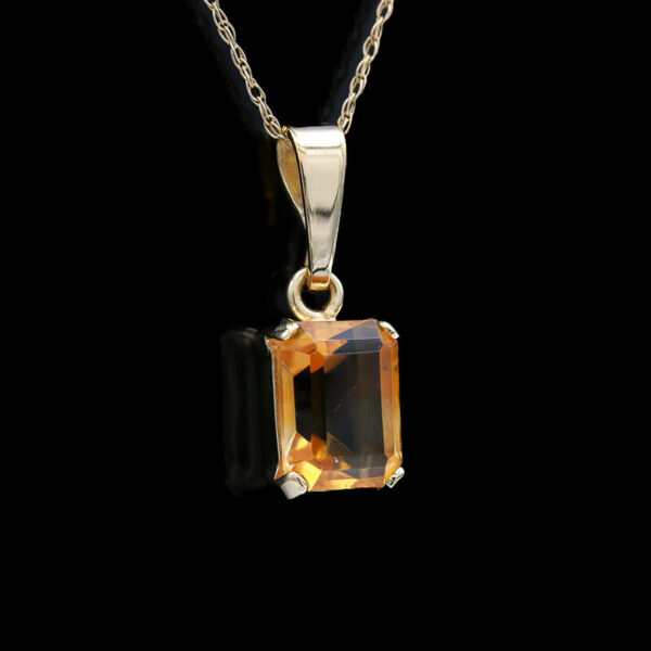 a pendant with an orange topazte on a black background