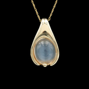 a gold pendant with a blue stone in the center