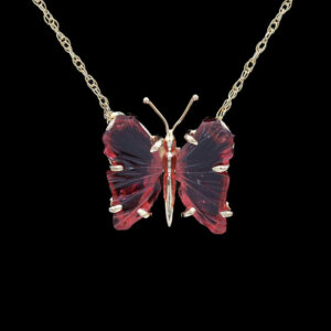a red butterfly necklace on a chain