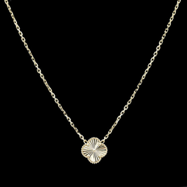 a gold necklace with a flower on it