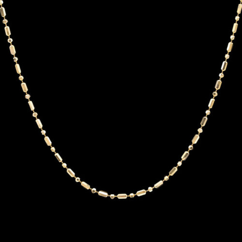 a gold necklace on a black background