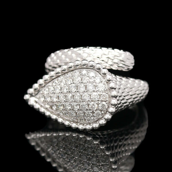 a white gold and diamond ring on a reflective surface