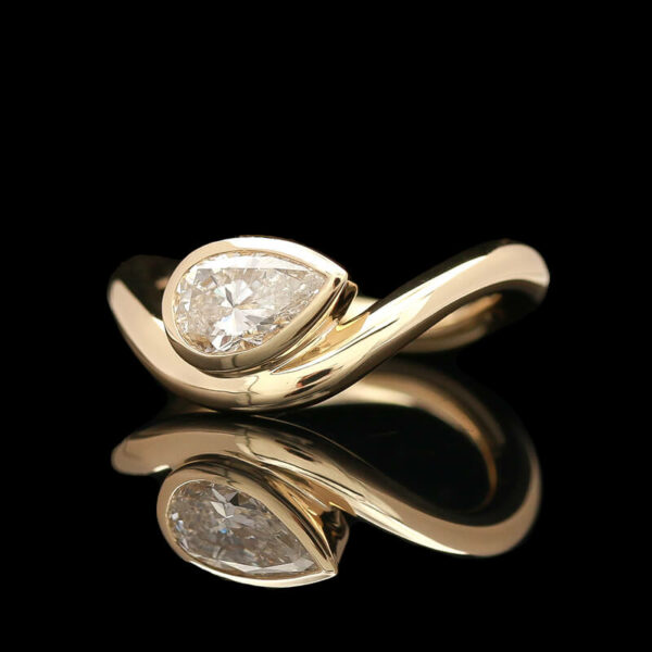 a gold ring with two pear shaped diamonds