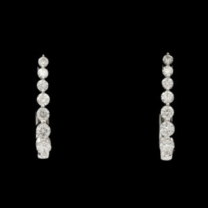 a pair of diamond earrings on a black background