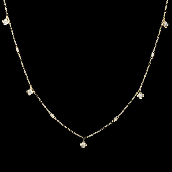 a gold necklace with white stones on a black background