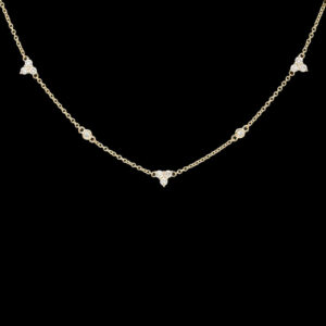 a gold necklace with five diamonds on it