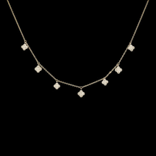 a gold necklace with four square shaped diamonds