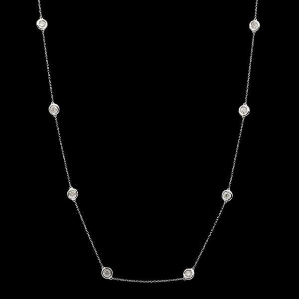 a necklace with white diamonds on a black background