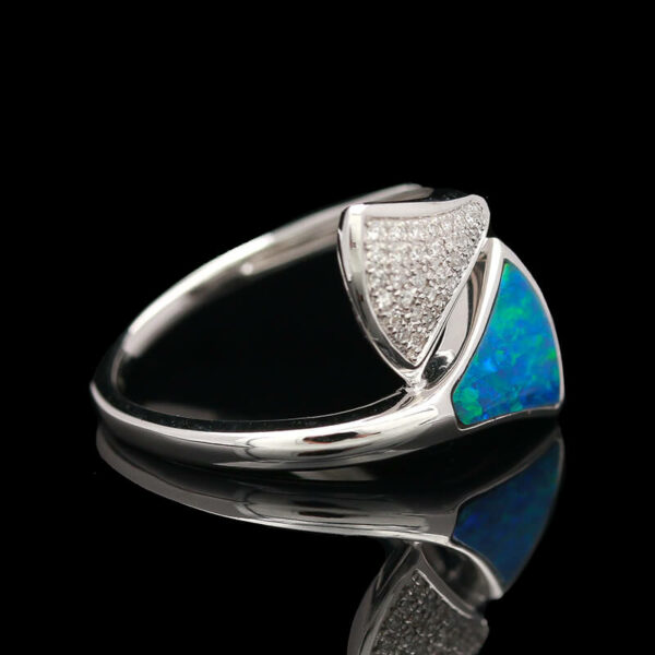 an opal and diamond ring on a black background