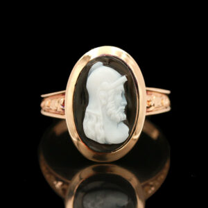 a gold ring with a carved white bust