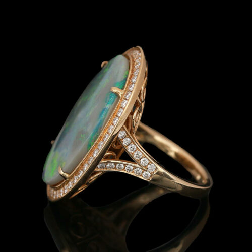an opalite and diamond ring on a black background