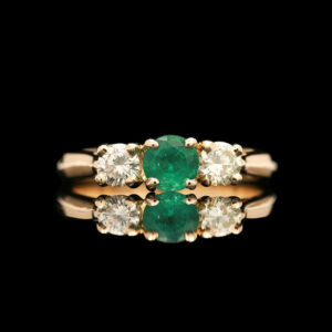 an emerald and diamond three stone ring
