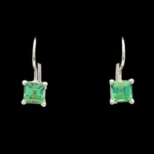 a pair of earrings with an emerald colored stone
