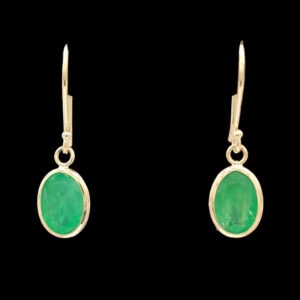 a pair of earrings with green stones on them