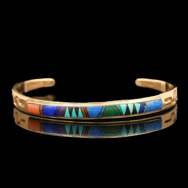 a gold bracelet with multicolored stones on it