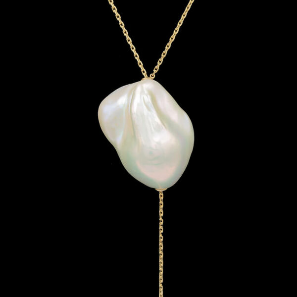 a long necklace with a large white shell hanging from it