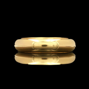 a yellow gold wedding band on a black background